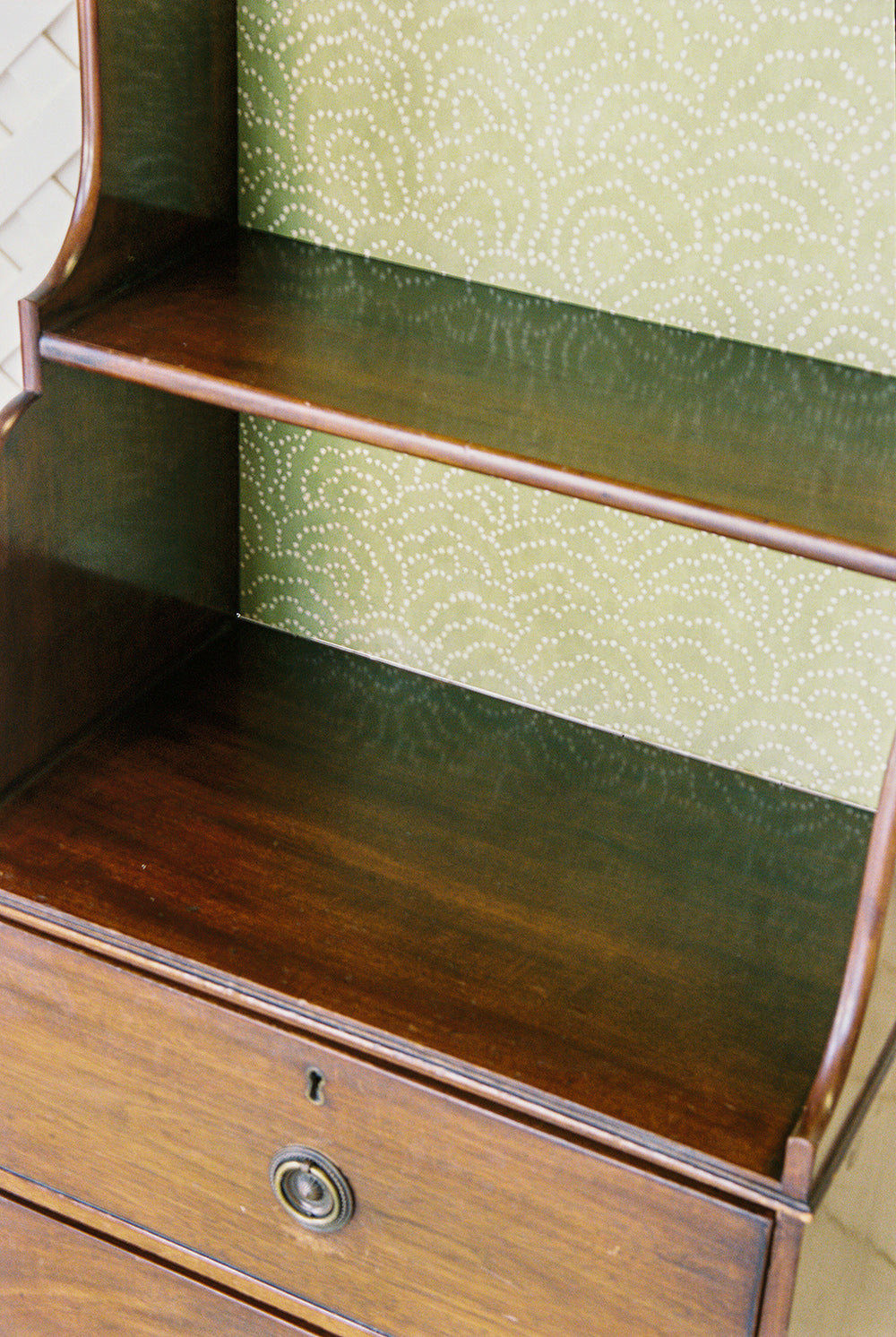 Georgian style mahogany waterfall bookcase with graduated shelves and two drawers, close view