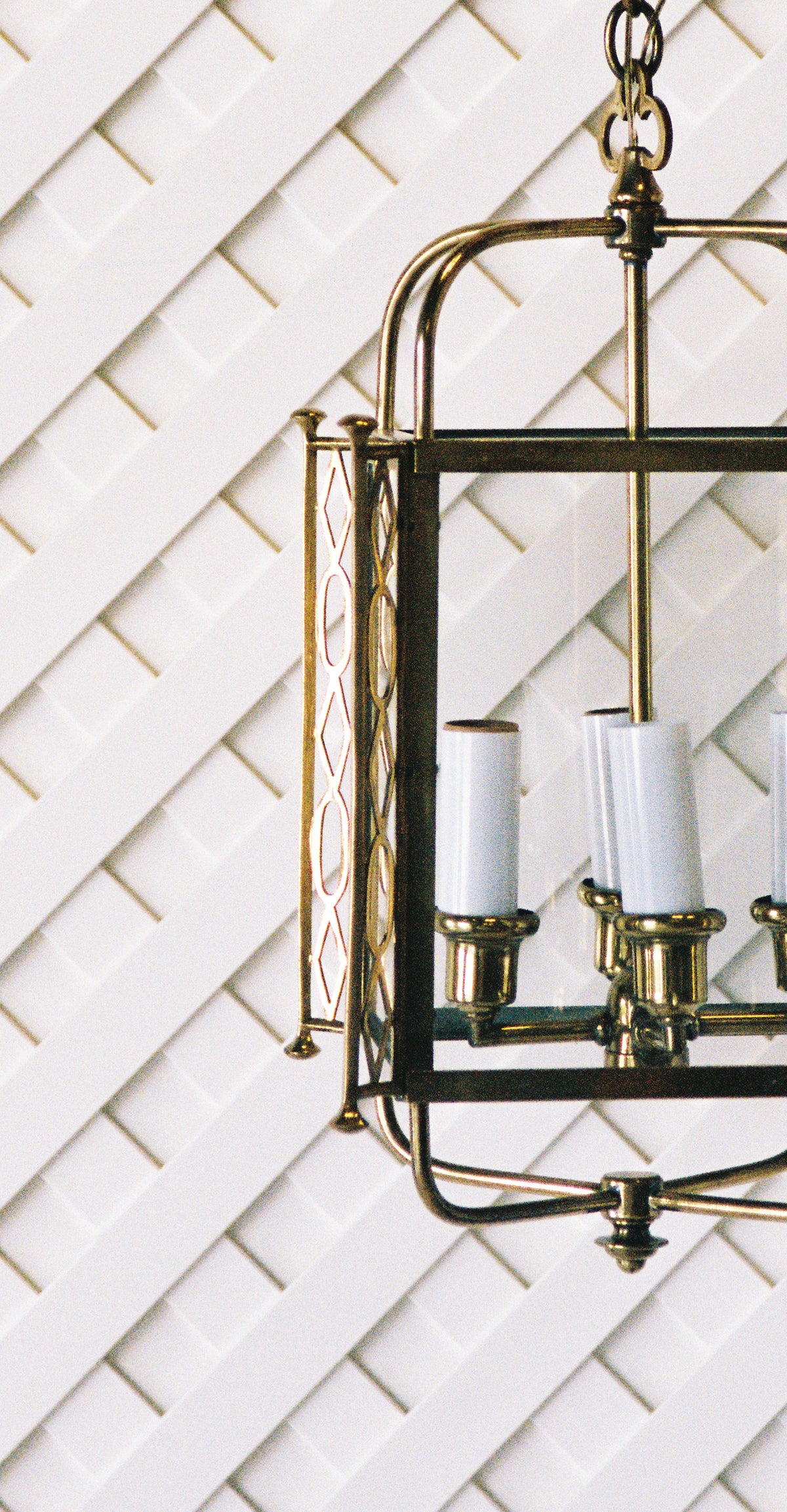 Close view of the brass lantern frame, glass panels and four candle lights