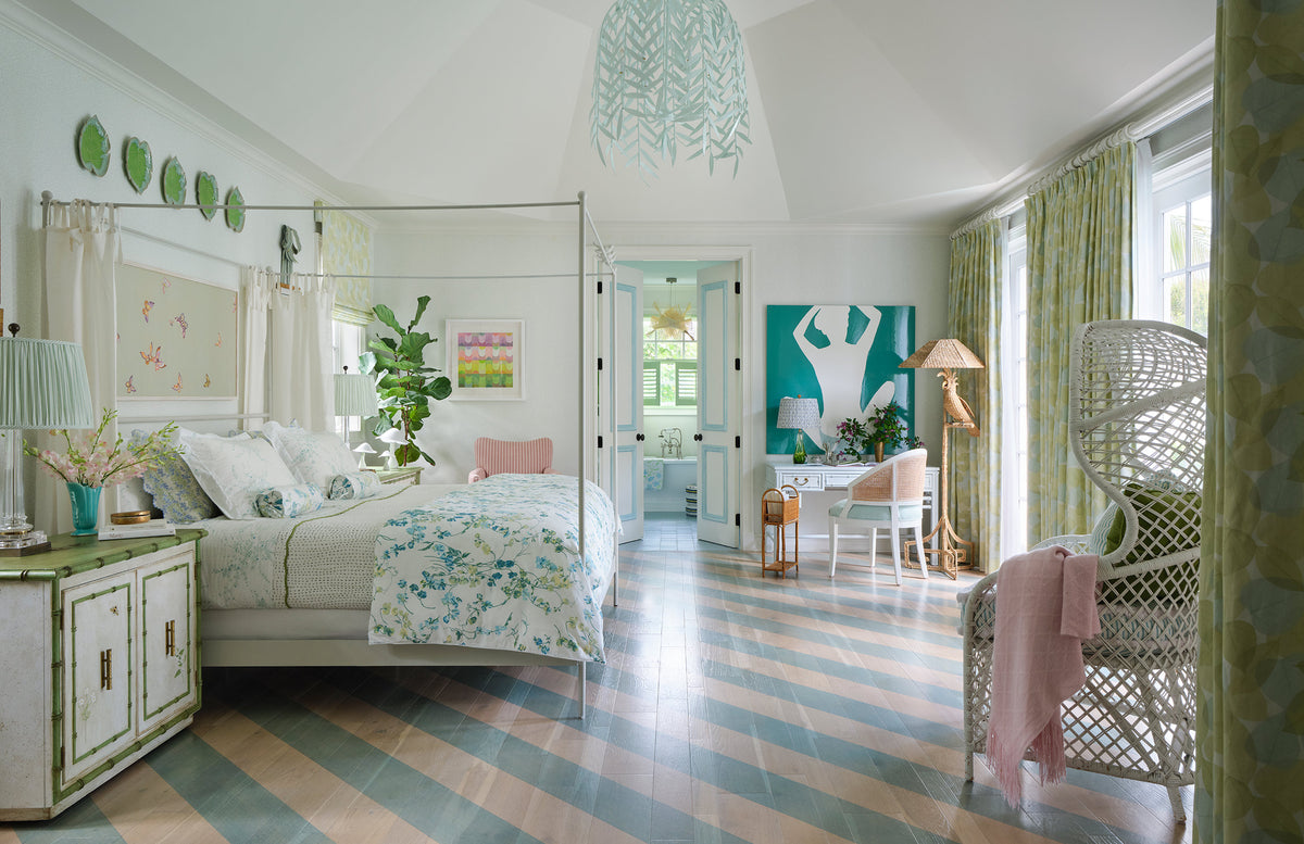 Bedroom with a white canopy bed, green plates on the wall and a blue and white striped floor