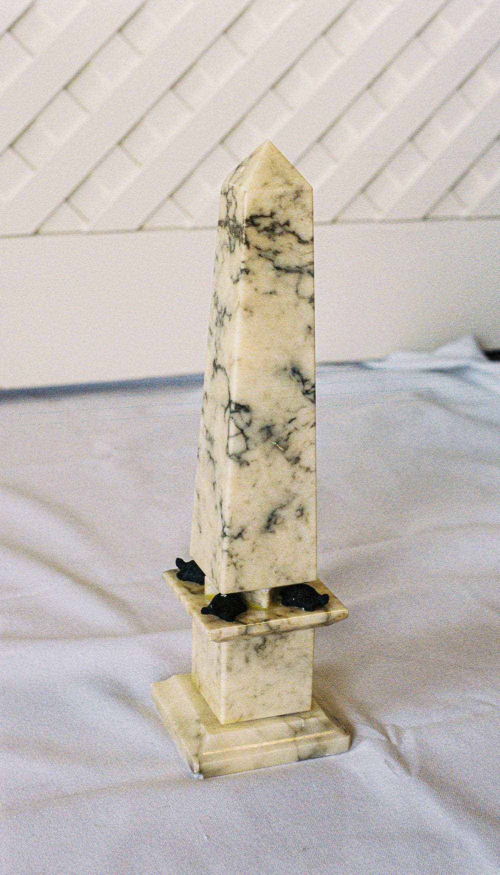 Alabaster obelisk with a turtle at each corner of its base, from the side