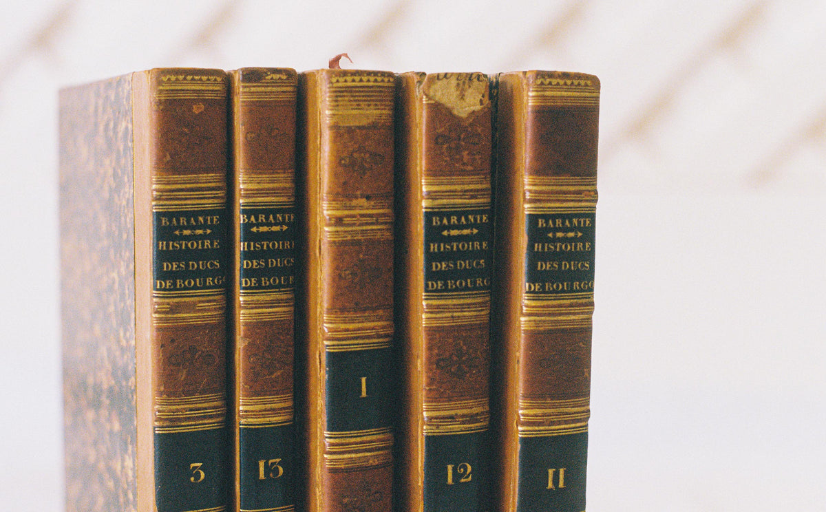 Five leather bound volumes of Barante, Histoire des Ducs de Bourgogne, with gilt spines and marbled boards, close view