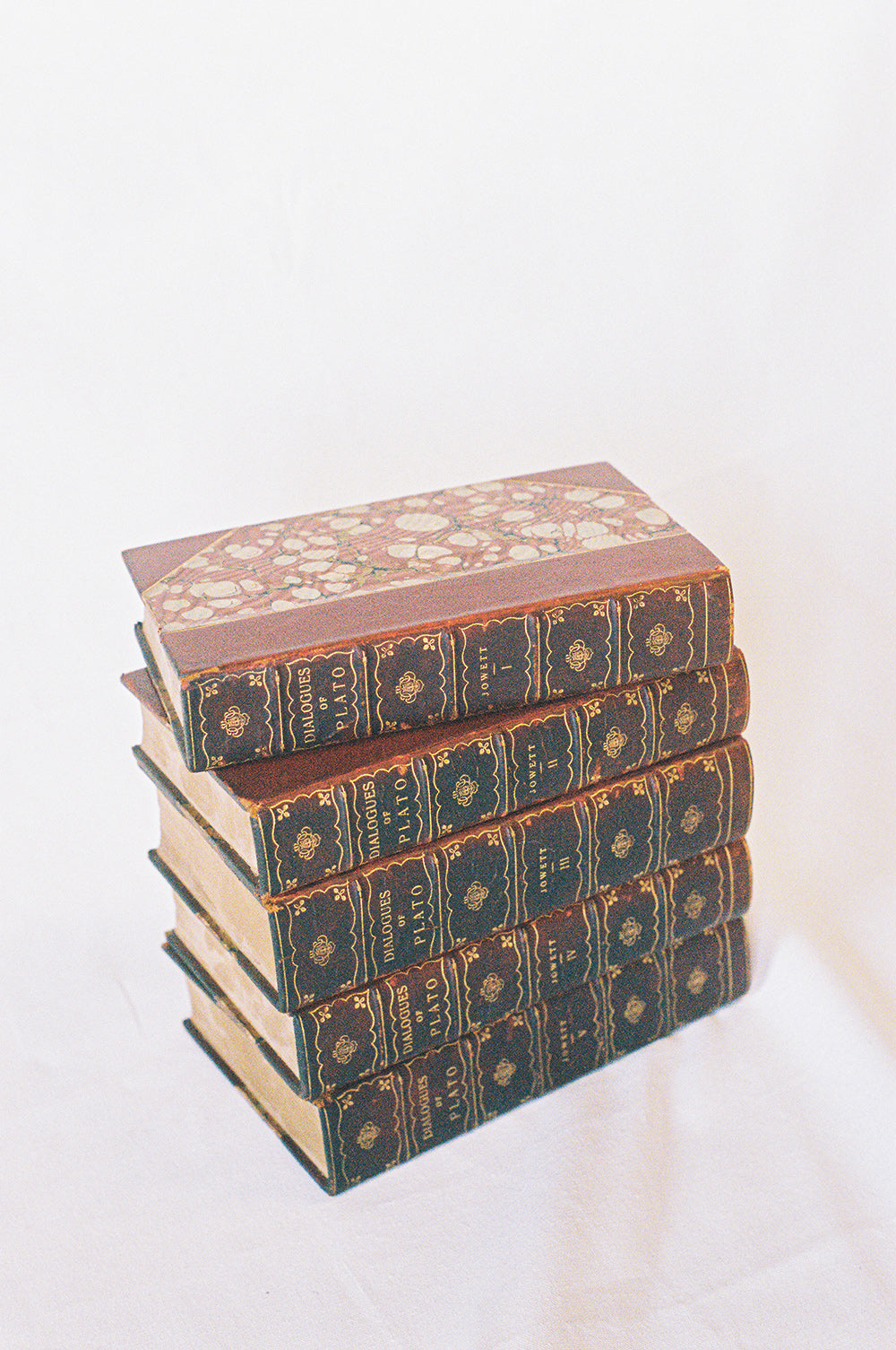 Five leather bound volumes of the Dialogues of Plato, translated by Jowett, with gilt tooled spines, from the side
