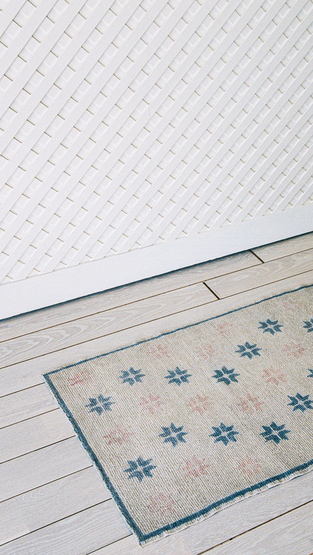 Wool runner with a starburst pattern in white, pink and blue, from the side
