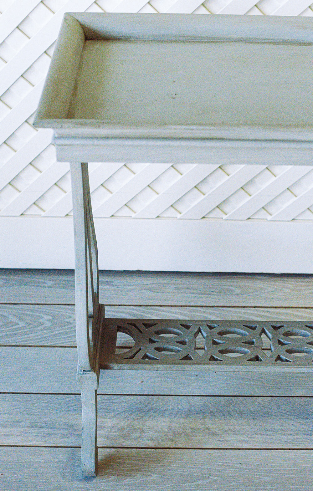 Gray washed side table with a tray top and a pierced lower shelf