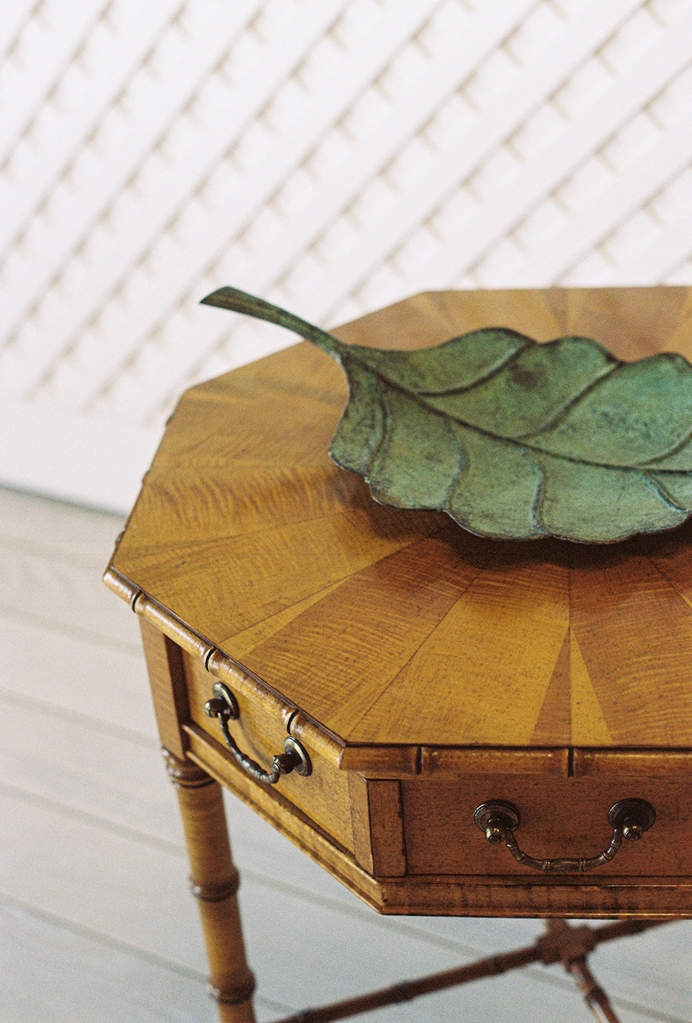 Octagonal bamboo end table with one drawer and a starburst veneer top