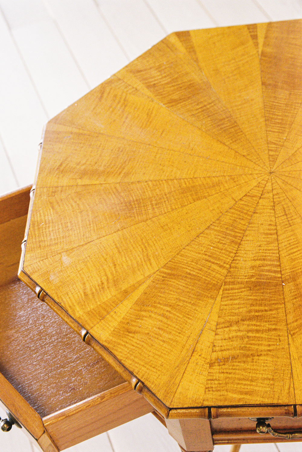 Octagonal bamboo end table with one drawer and a starburst veneer top