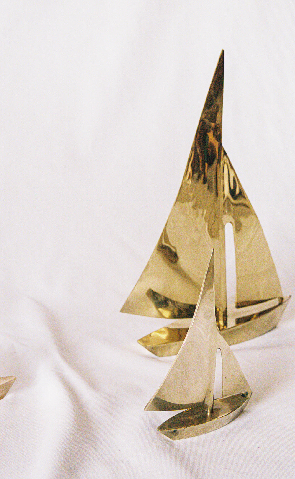 Three solid brass sailboats in graduated sizes