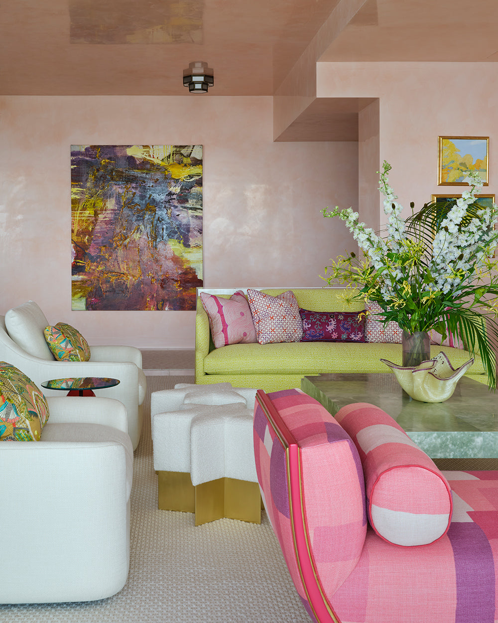 Sitting room with an abstract canvas, a chartreuse sofa, a pink striped chaise and white swivel chairs